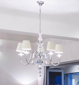 A chandelier with white shades is hanging from the ceiling