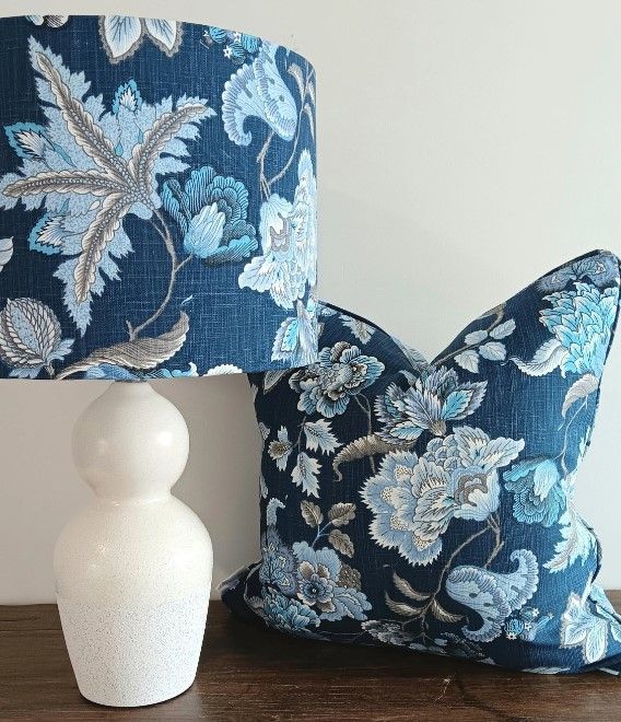 A lamp and a pillow with blue flowers on them