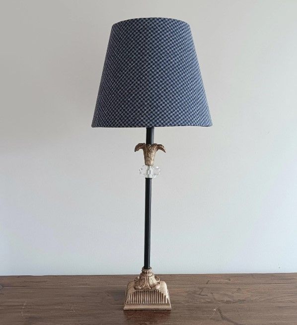 A lamp with a blue shade is sitting on a wooden table.