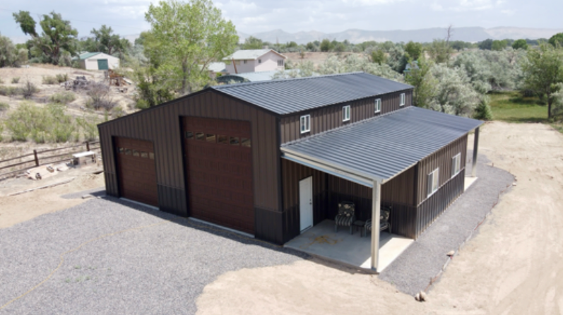 An aerial view of a large metal building with a garage and porch.