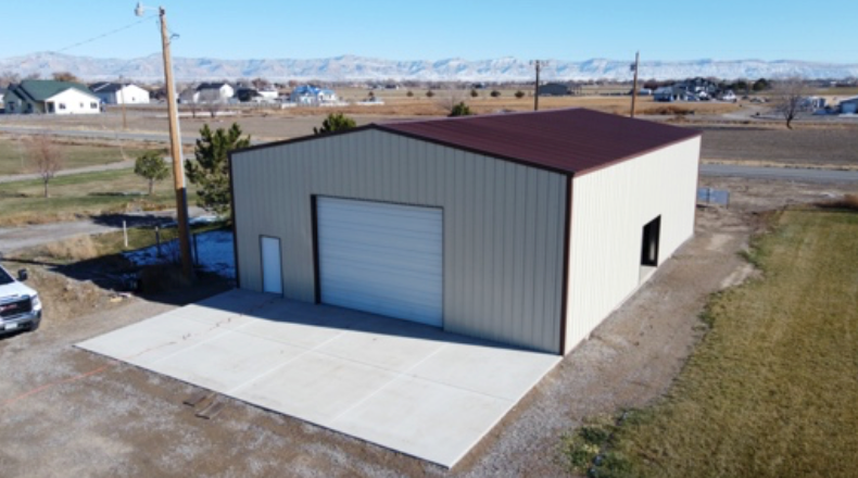 An aerial view of a large metal building with a large garage door.