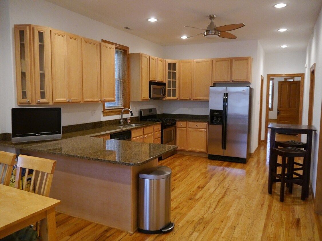 Mechanic fixing exercise equipment, wearing gloves, surrounded by tools, gym setting.