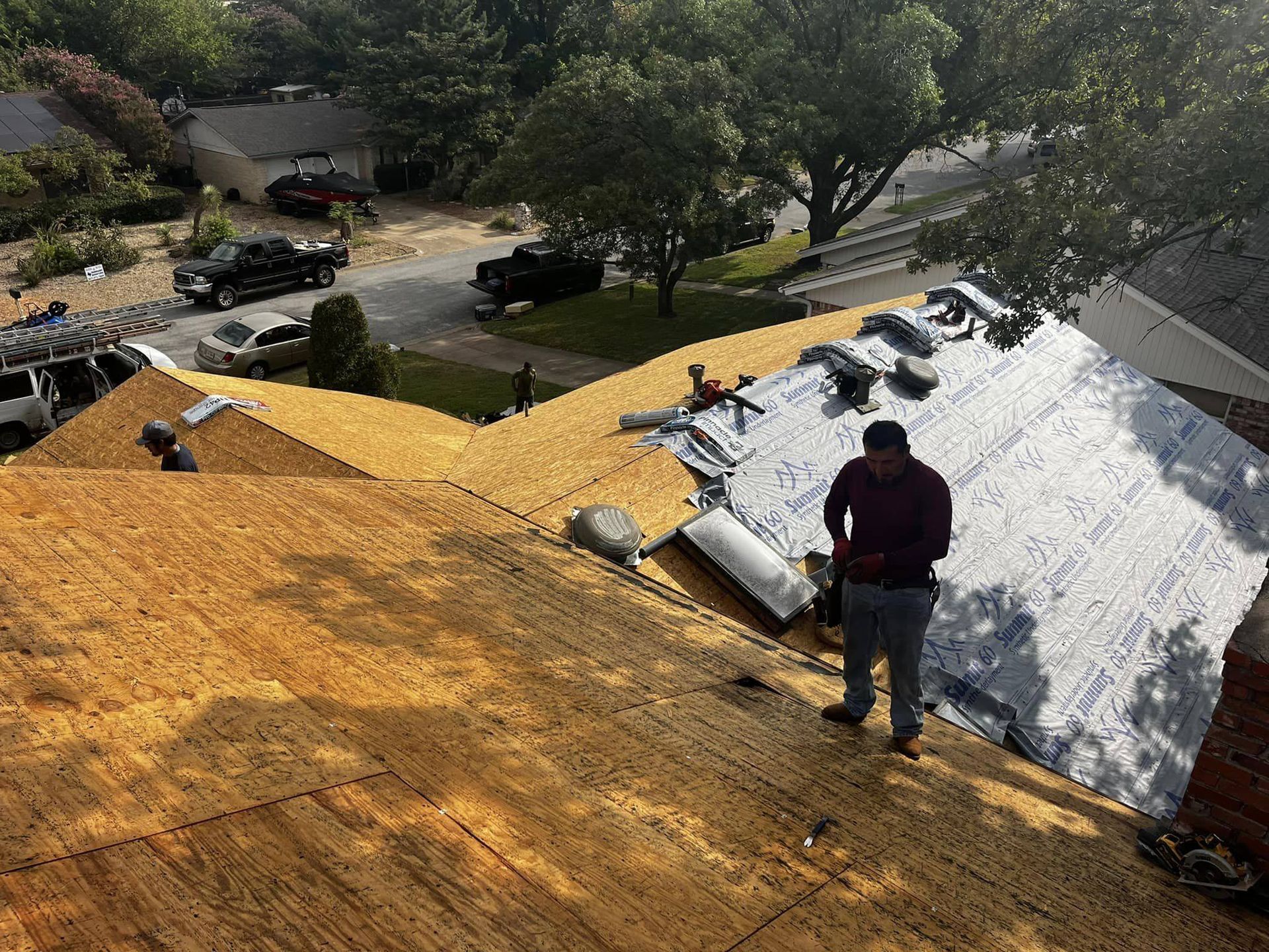 A man is standing on the roof of a house.