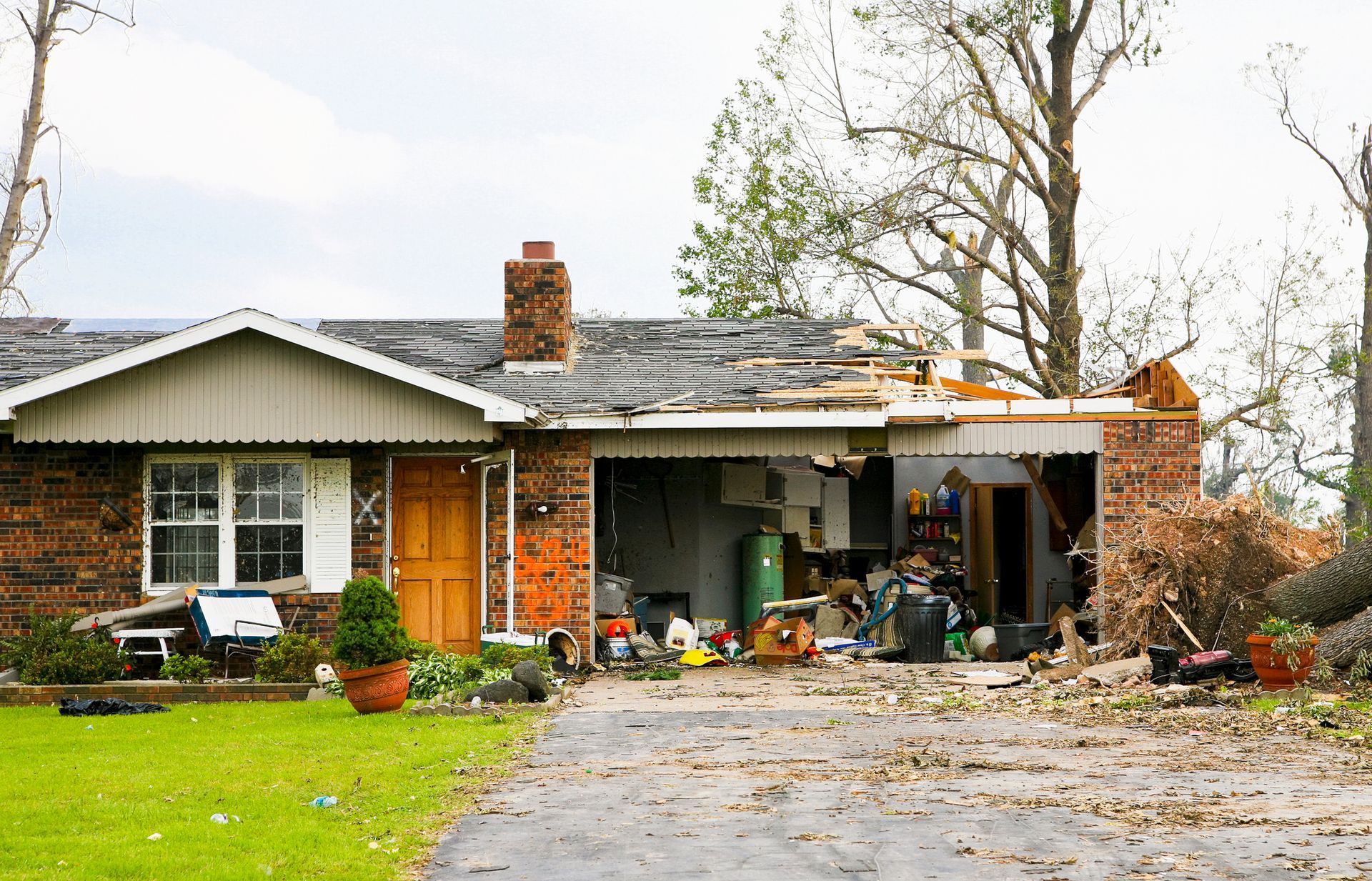 A house with a roof that has been damaged by a tornado