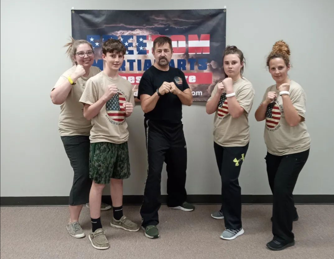 a group of people standing in front of a sign that says martial arts
