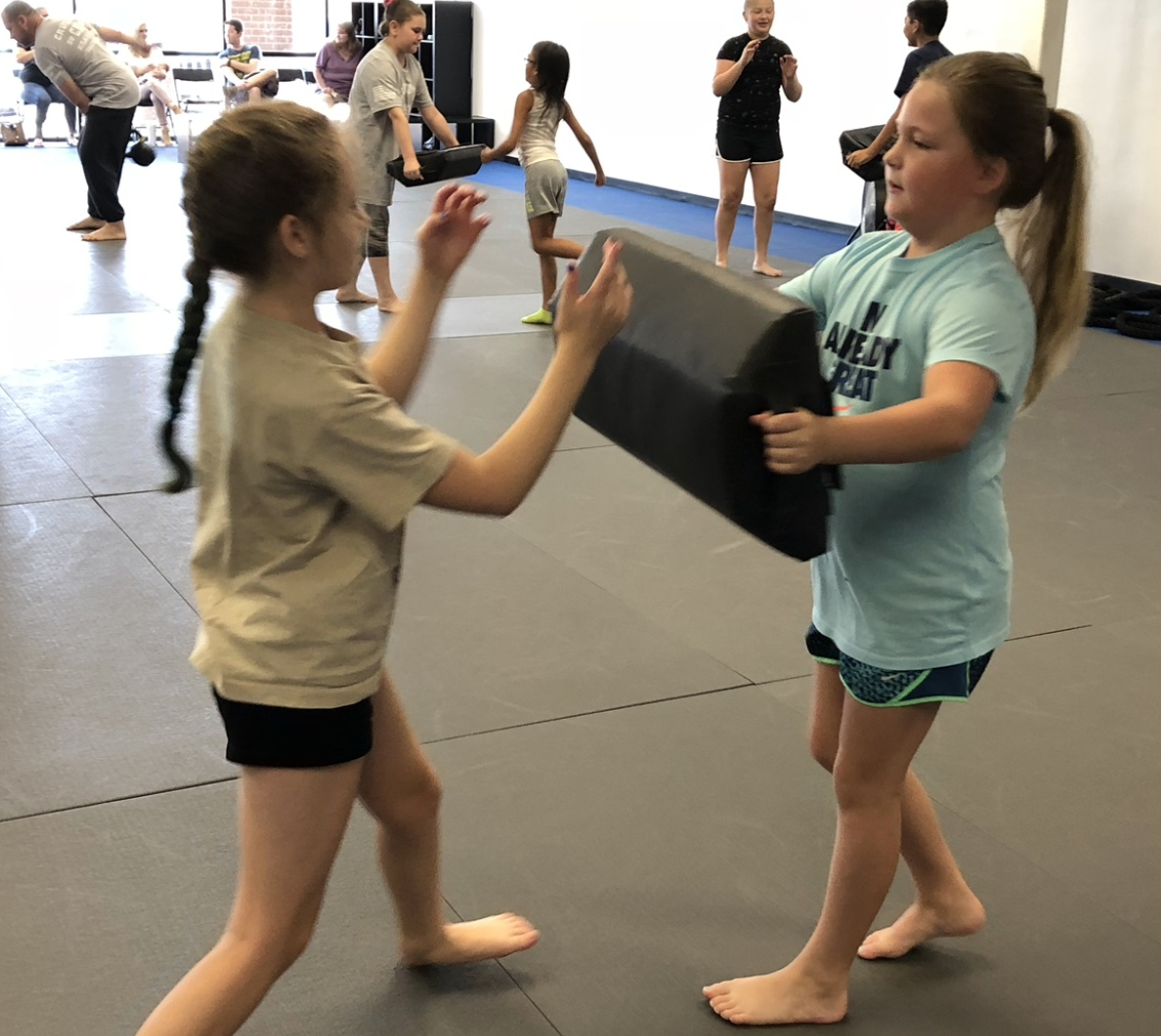 a girl wearing a shirt that says karate on it