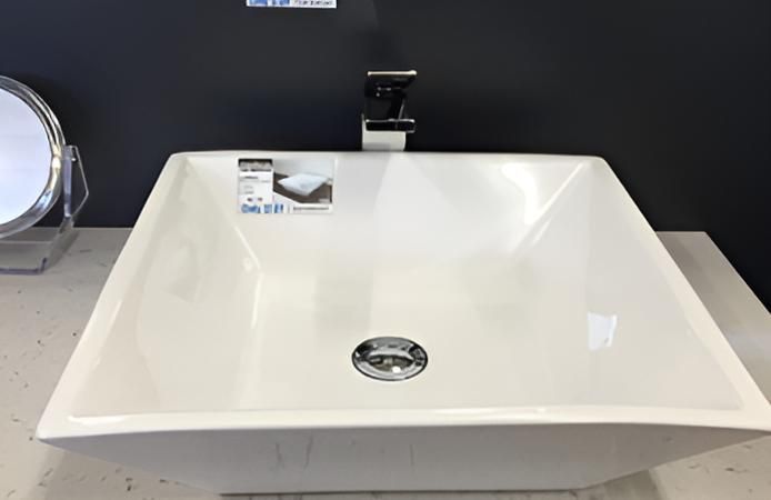 A White Sink Is Sitting On A Counter Next To A Mirror — Coastal Gasfitting & Plumbing In Mount ST John, QLD