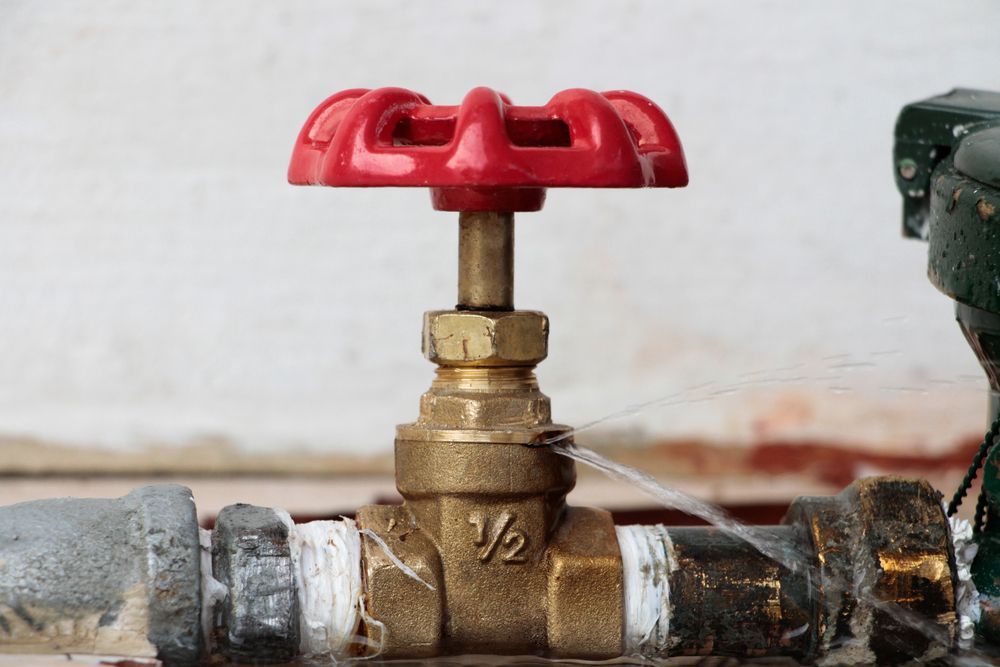 A Brass Valve With A Red Handle Is Leaking Water — Coastal Gasfitting & Plumbing In Bushland Beach, QLD