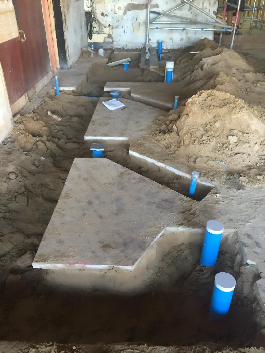 A Bunch Of Pipes Are Being Installed In A Hole In The Ground — Coastal Gasfitting & Plumbing In Mount ST John, QLD