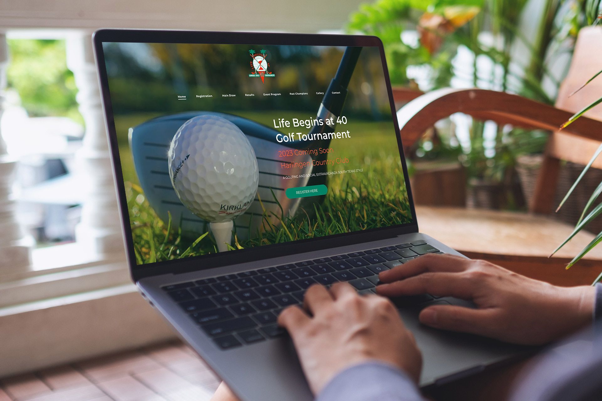 A person is typing on a laptop computer with a golf ball on the screen.