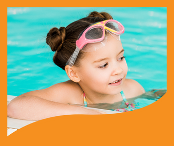 A little girl wearing goggles is swimming in a pool.