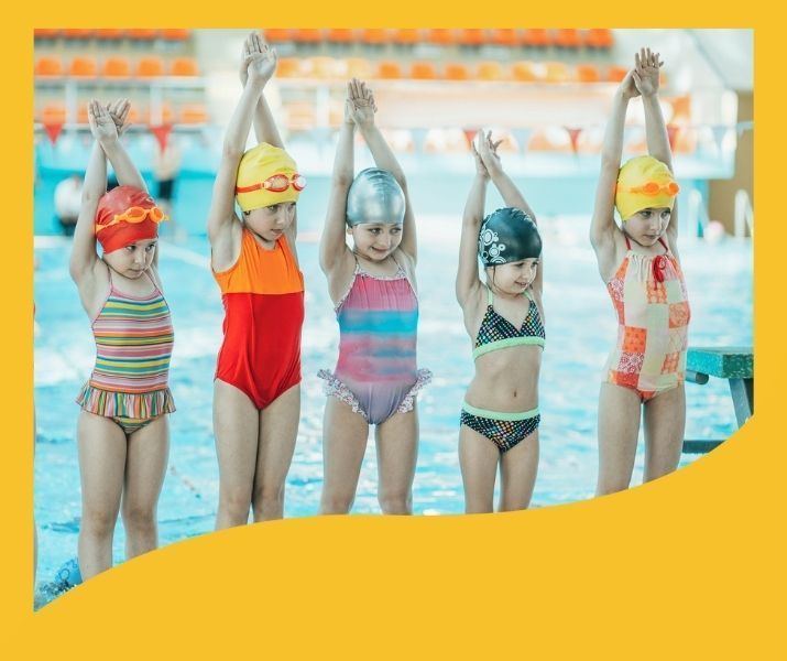 A group of young girls are standing next to each other in a swimming pool.