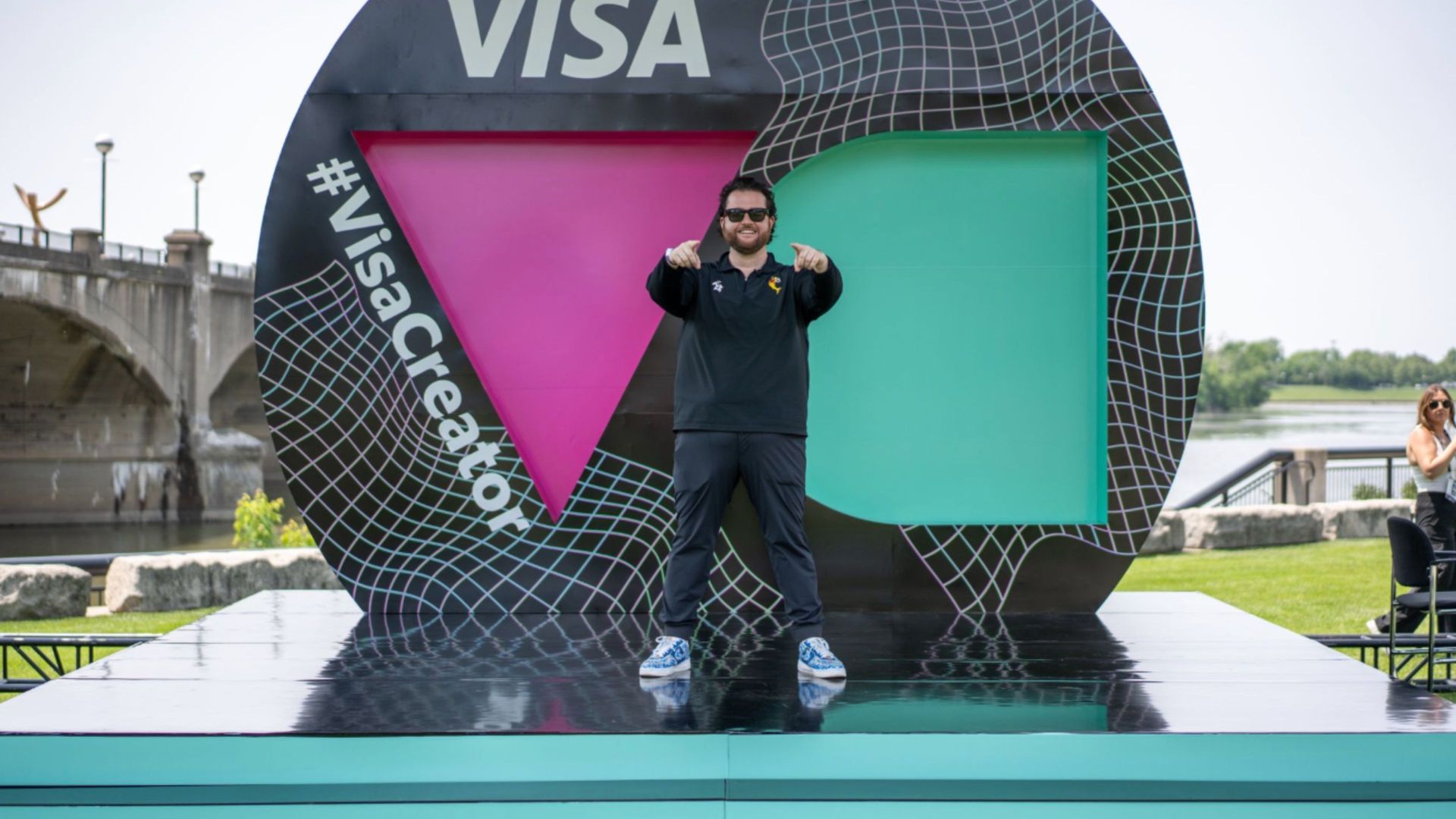 A man is standing in front of a visa sign.