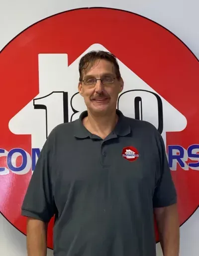 A man stands in front of a sign that says 100 doors