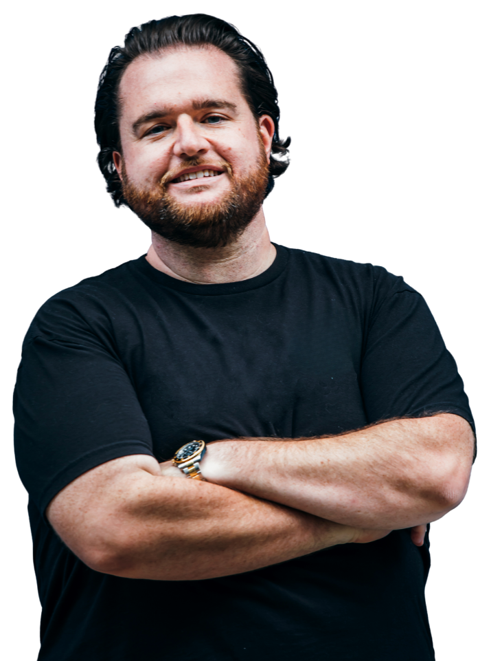 A man with a beard is standing with his arms crossed and wearing a watch.