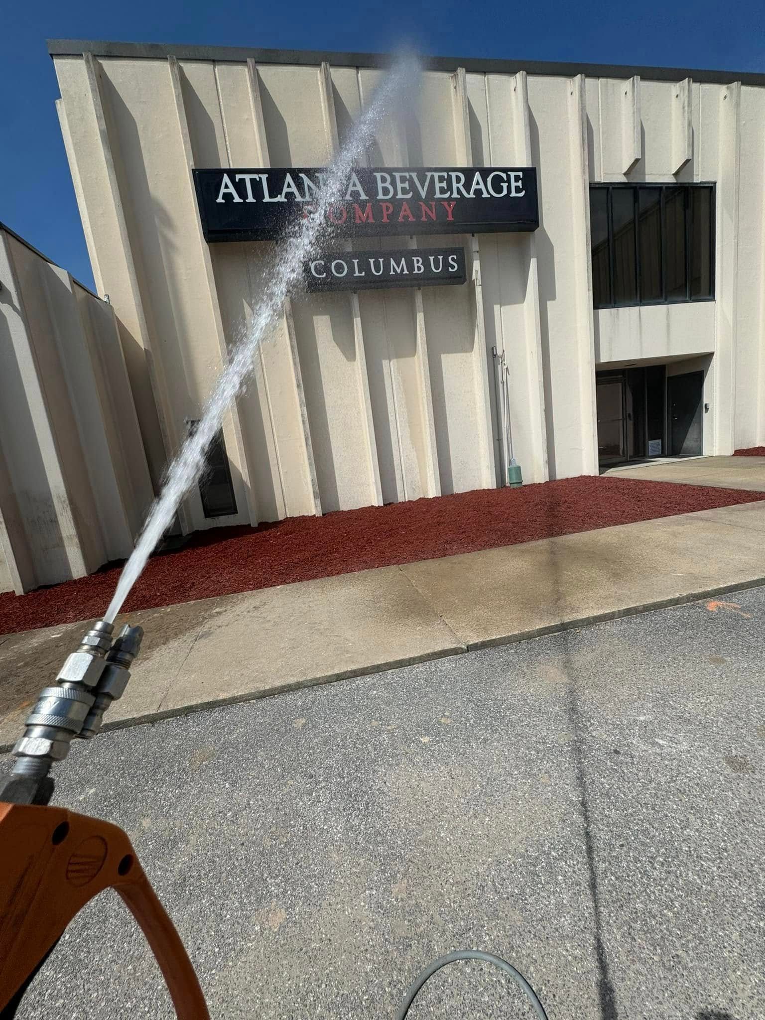 Pressure washer spraying water at the Atlanta Beverage Company building in Columbus.