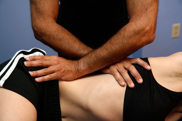 A man is giving a woman a massage on her back