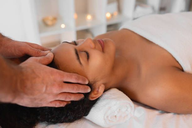 A woman is getting a head massage in a spa.