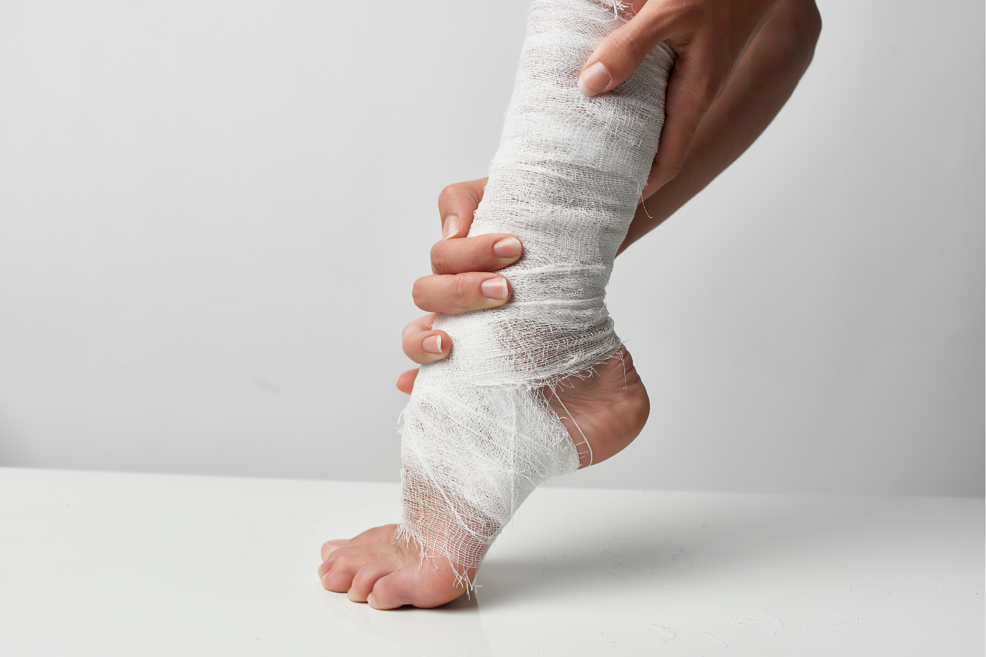A person is wrapping their leg in a bandage.