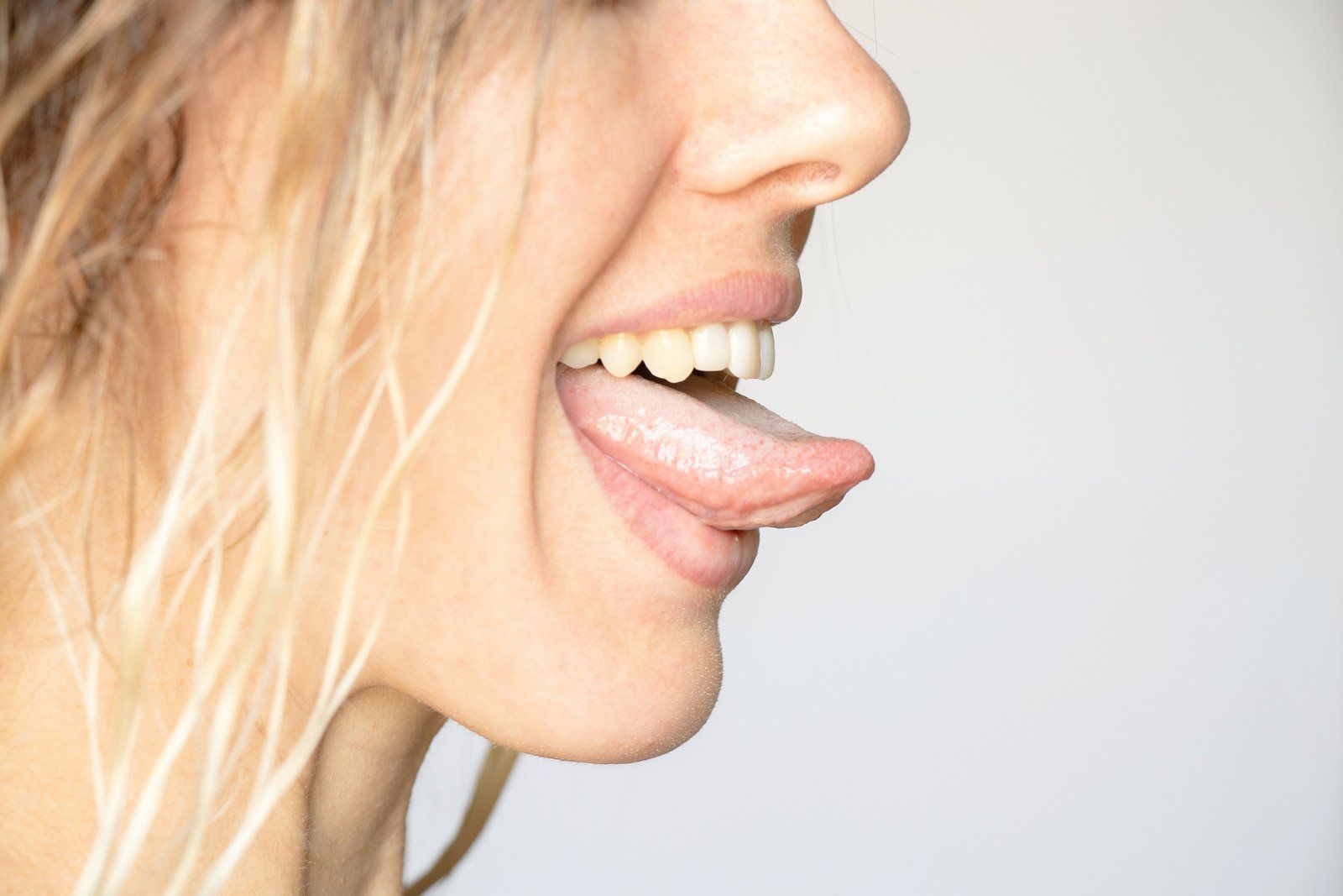 A close up of a woman 's face with her tongue sticking out.