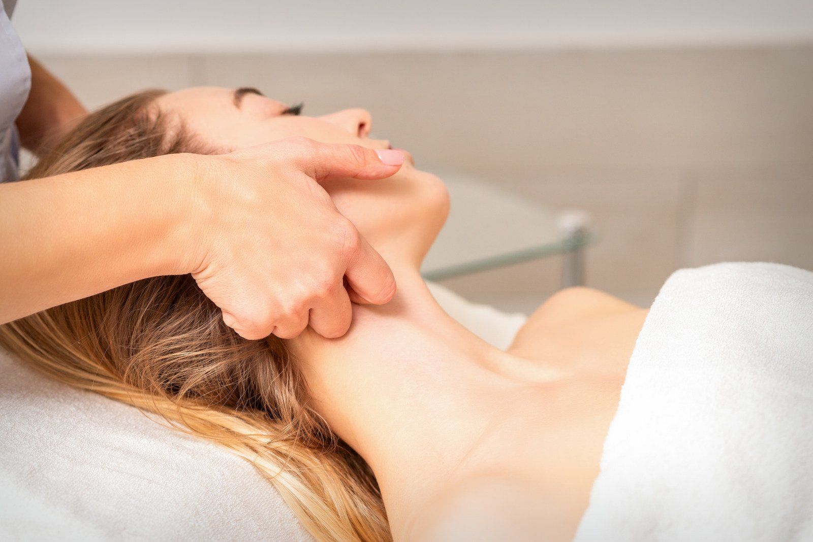 A woman is getting a neck massage at a spa.