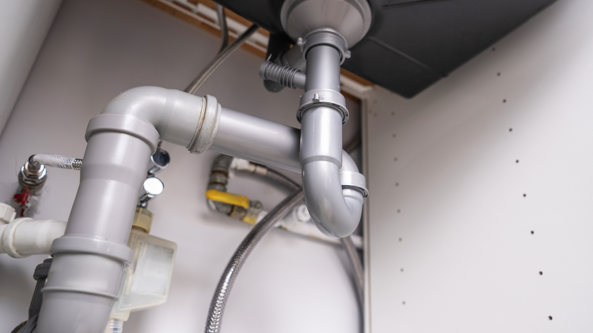 A close-up of a sink pipe in a kitchen
