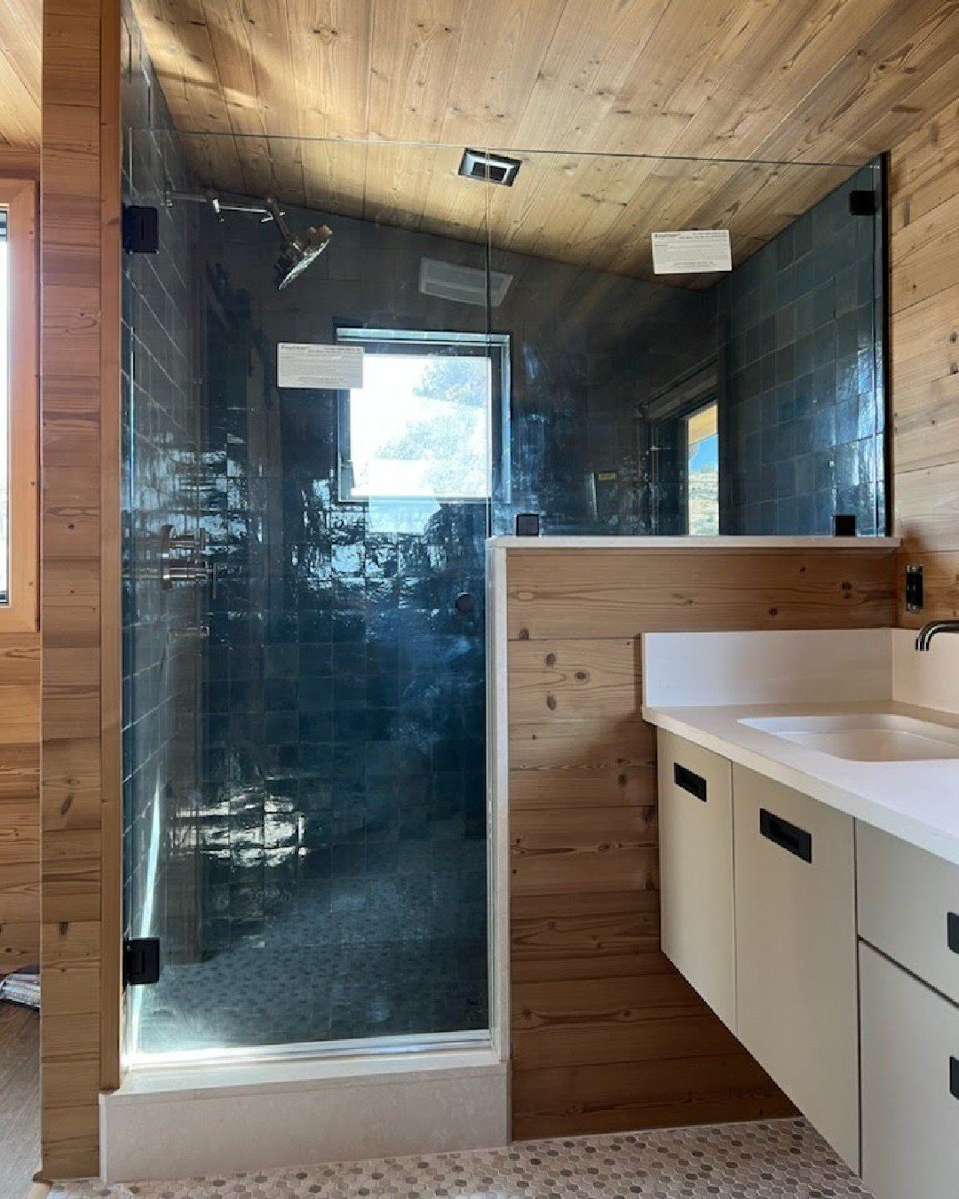 a bathroom with a walk in shower and shower glass installed by Sun Glass