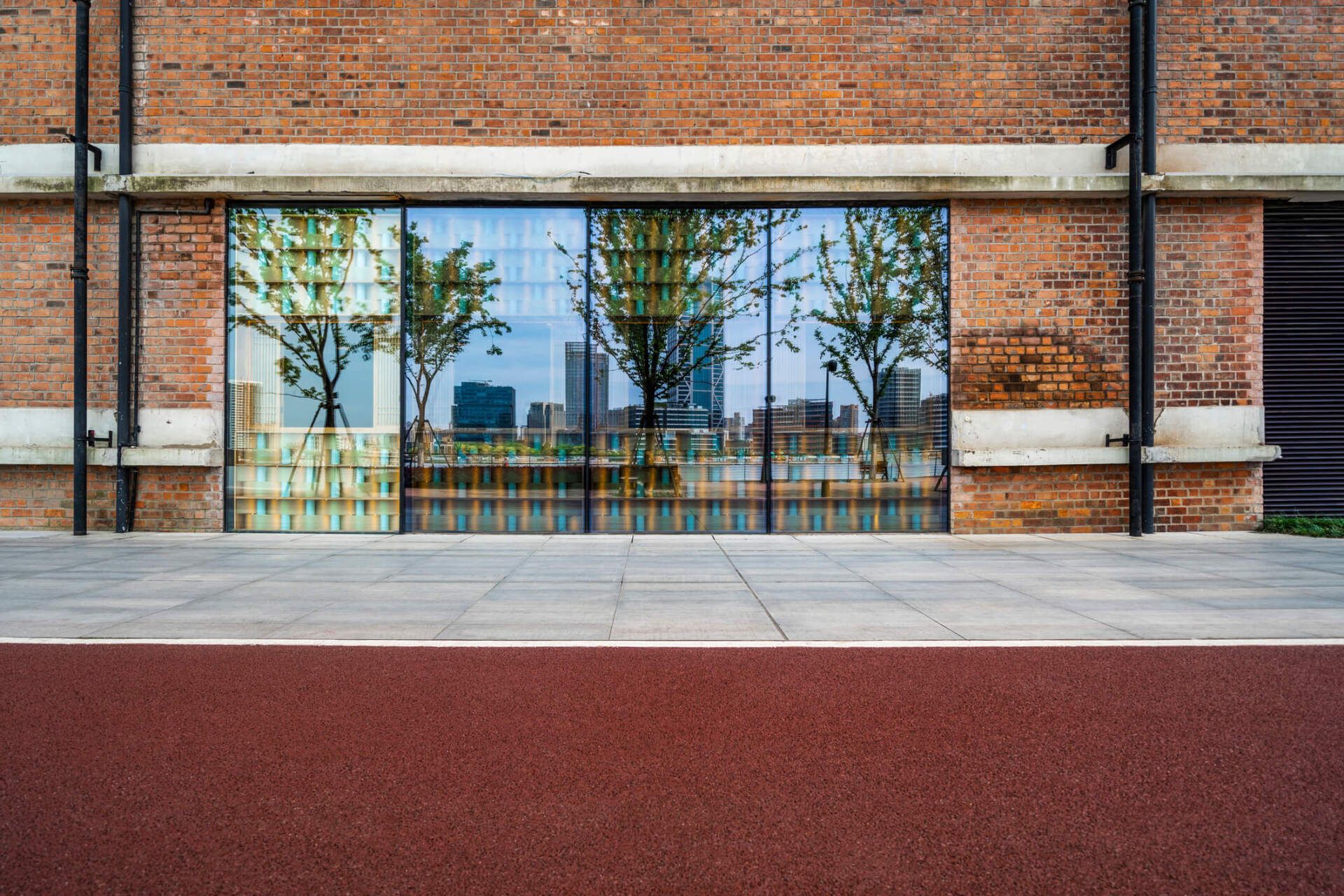A brick building with a large window and a red road in front of it. A brick building with a large window and a red road in front of it.