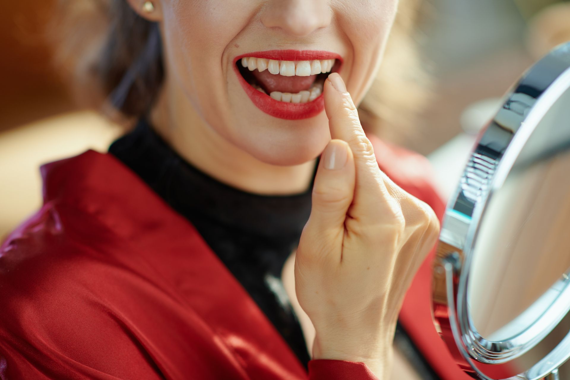 lady smiling and pointing to her tooth , red lips