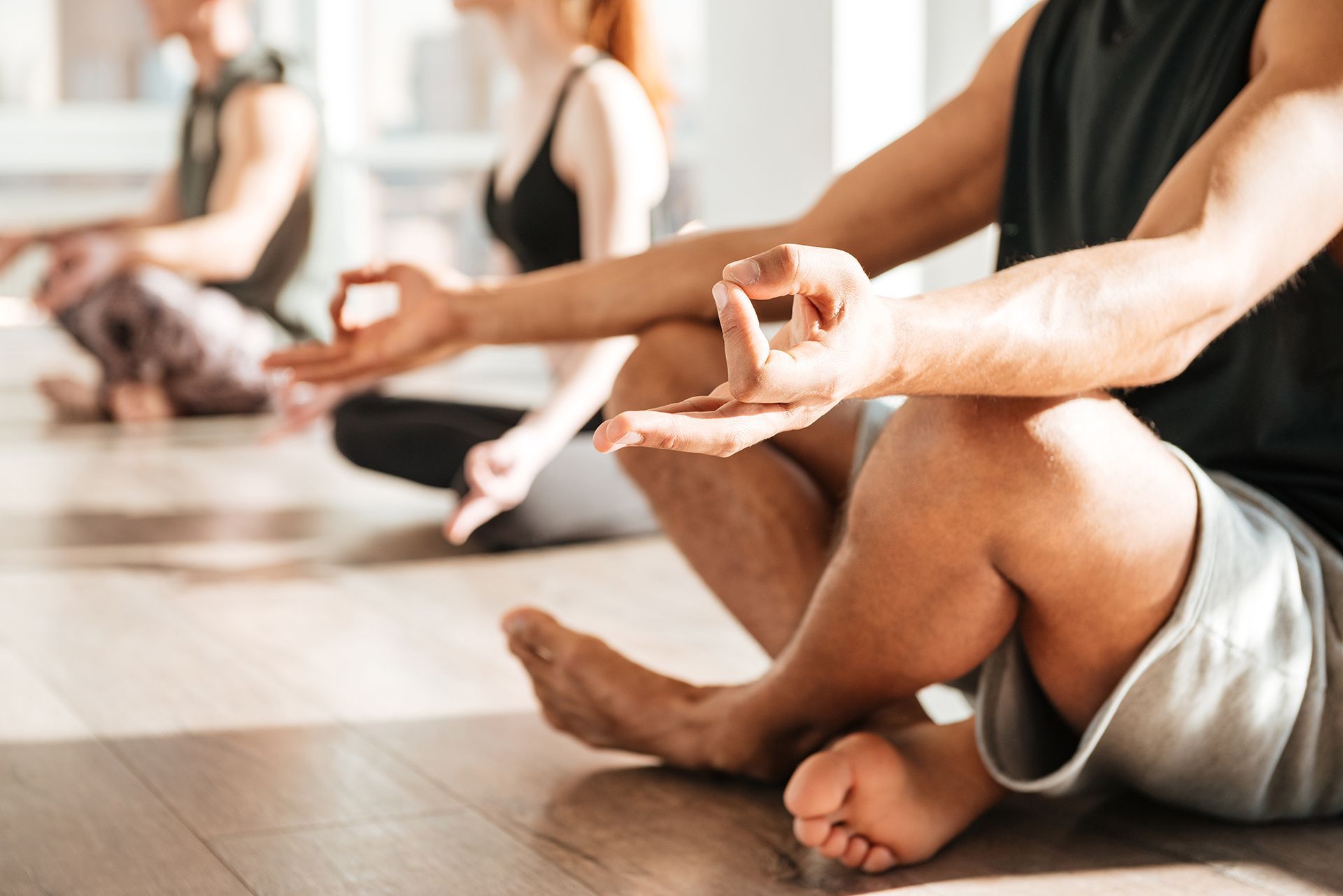 A group of people are sitting on the floor in a yoga class