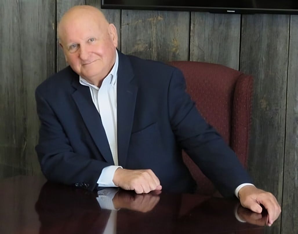 A woman is sitting on a bed leaning against a wall