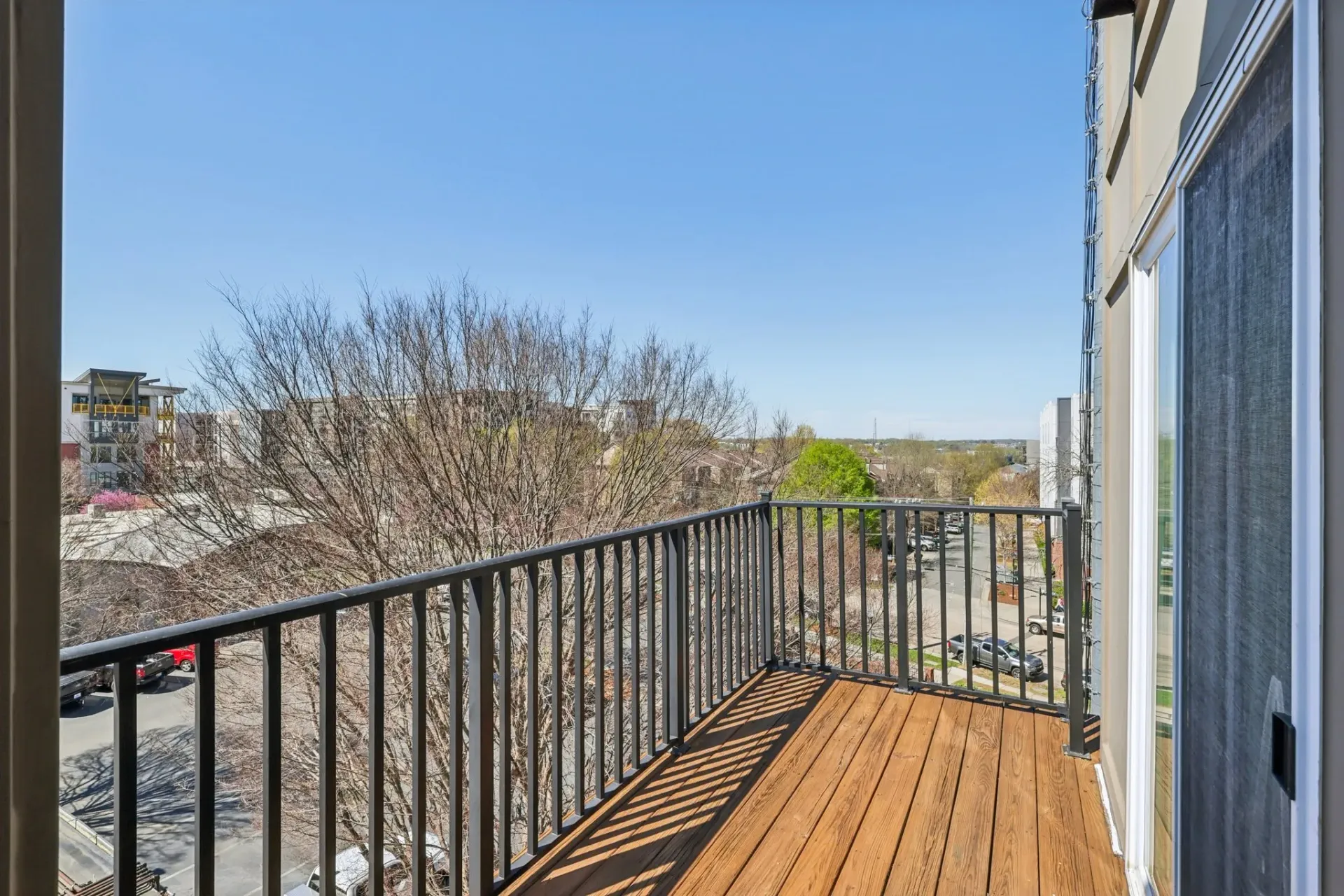 Balcony with wooden floor and railing overlooking the city