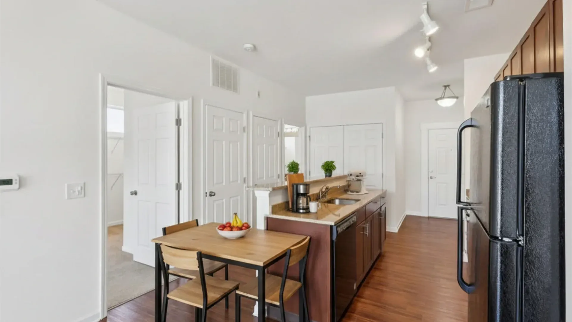 Kitchen and dining area with table and chairs, stainless steel appliances, and granite countertops.