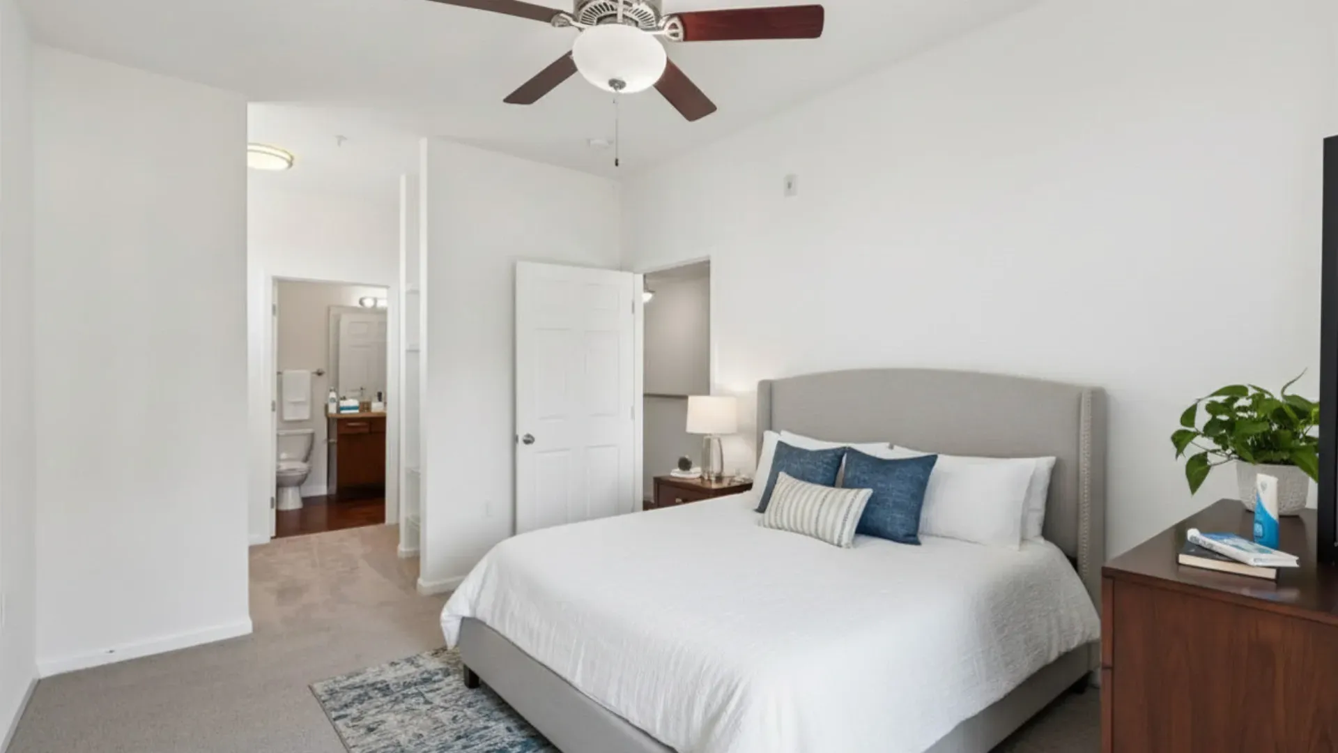Bedroom with king-size bed, ceiling fan, and access to bathroom.