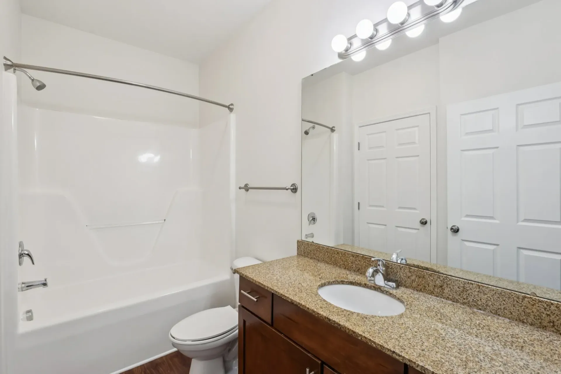Bathroom with a vanity, toilet, and bathtub/shower combo.