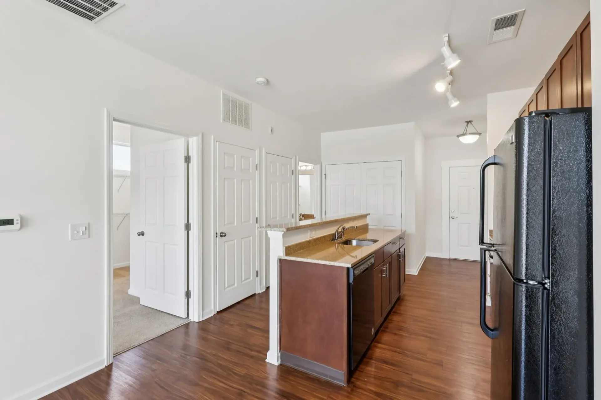 Modern kitchen with dark wood cabinets, granite countertops, and stainless steel appliances.