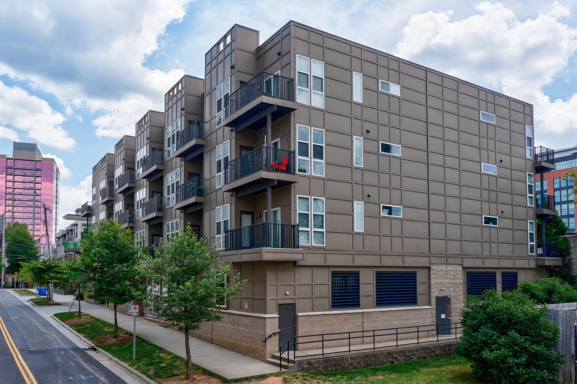 Modern apartment building with balconies on a city street.