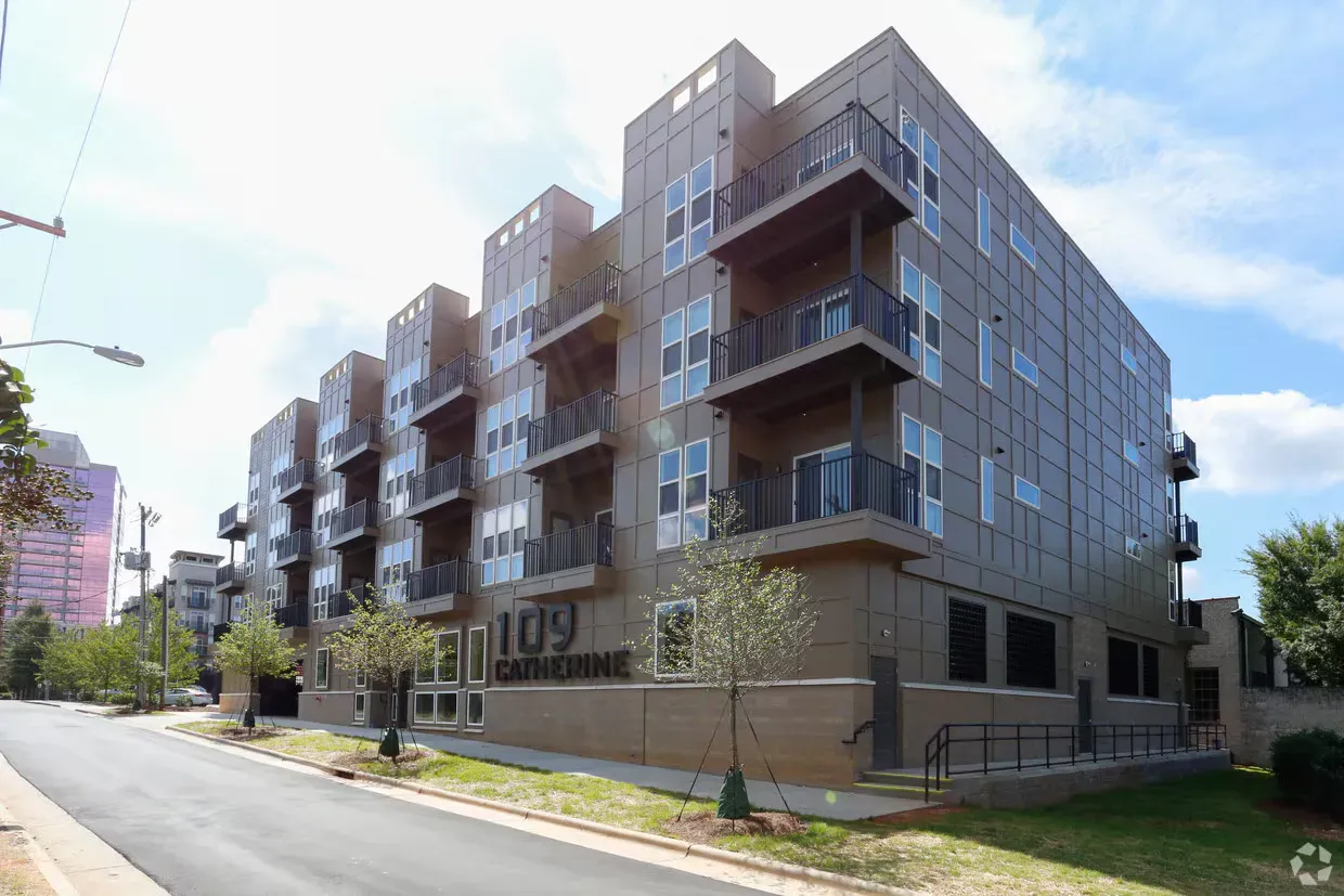 Modern apartment building, 109 South Ave, with balconies, concrete exterior, and some trees.