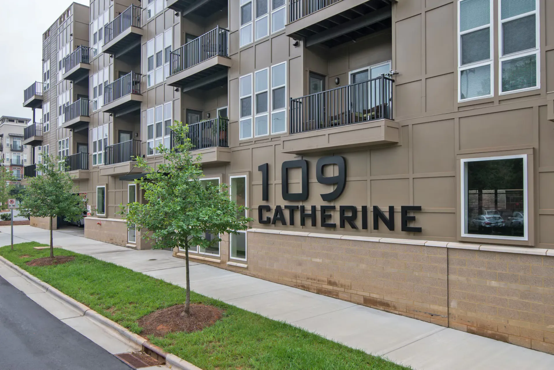 Exterior of the 109 Catherine apartment building with balconies and signage.