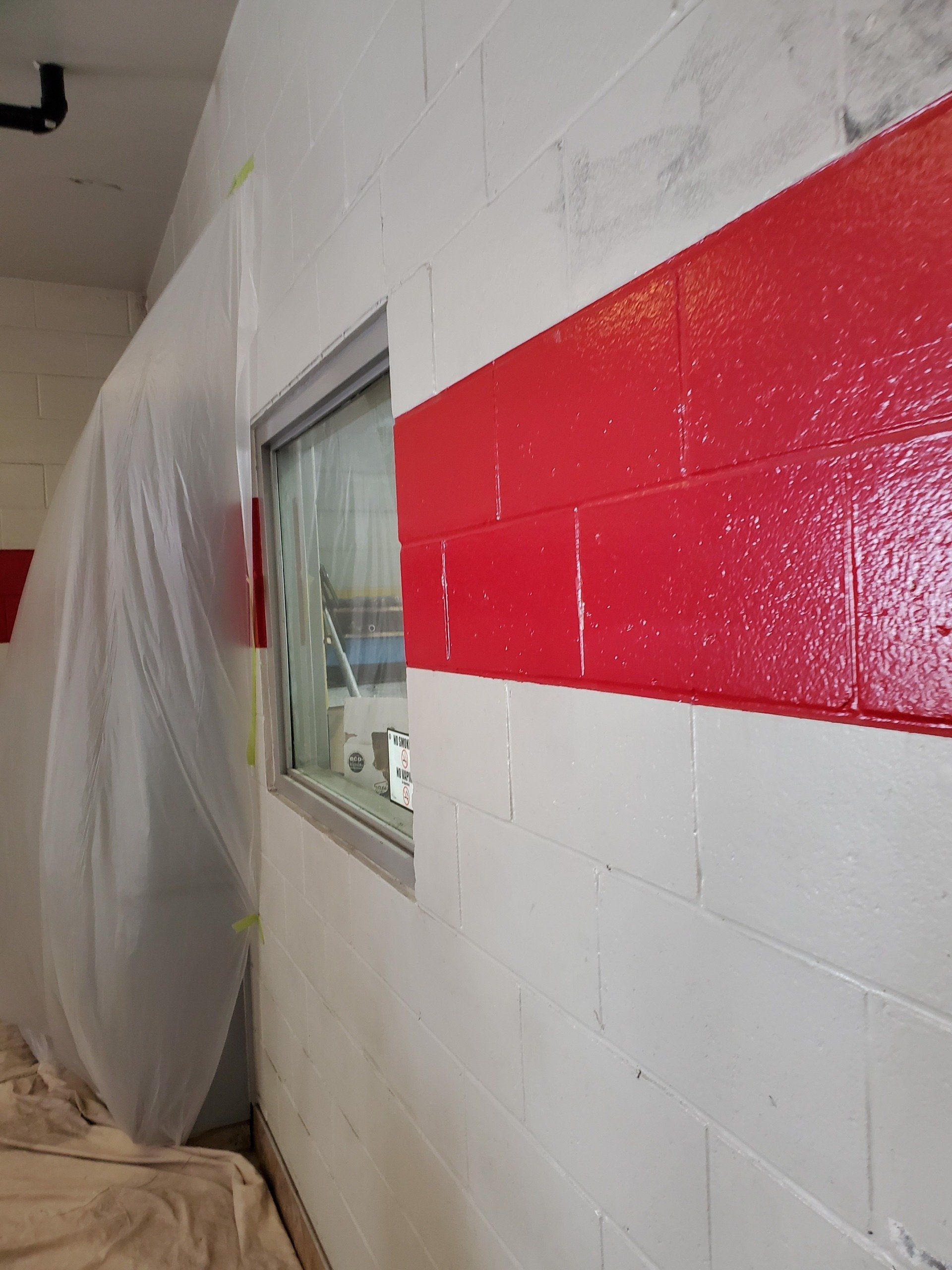 A red and white brick wall with a window.