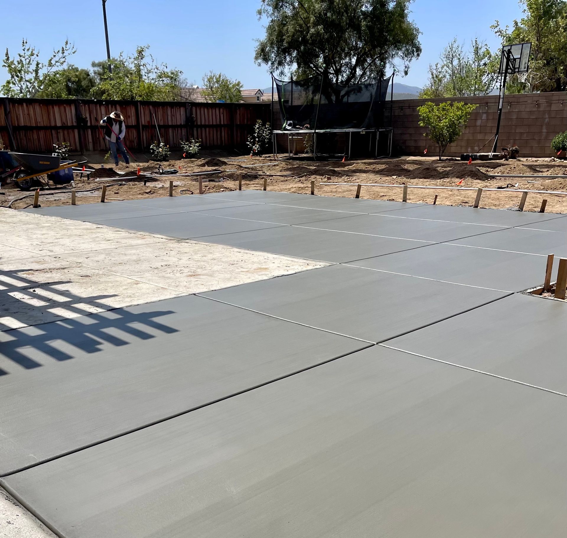 A concrete driveway with a fence in the background