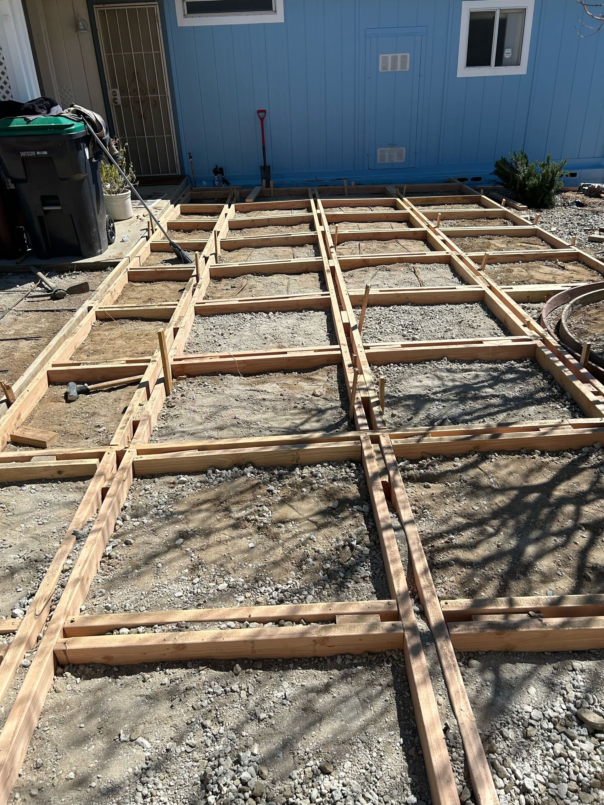 A wooden floor is being built in front of a blue house.