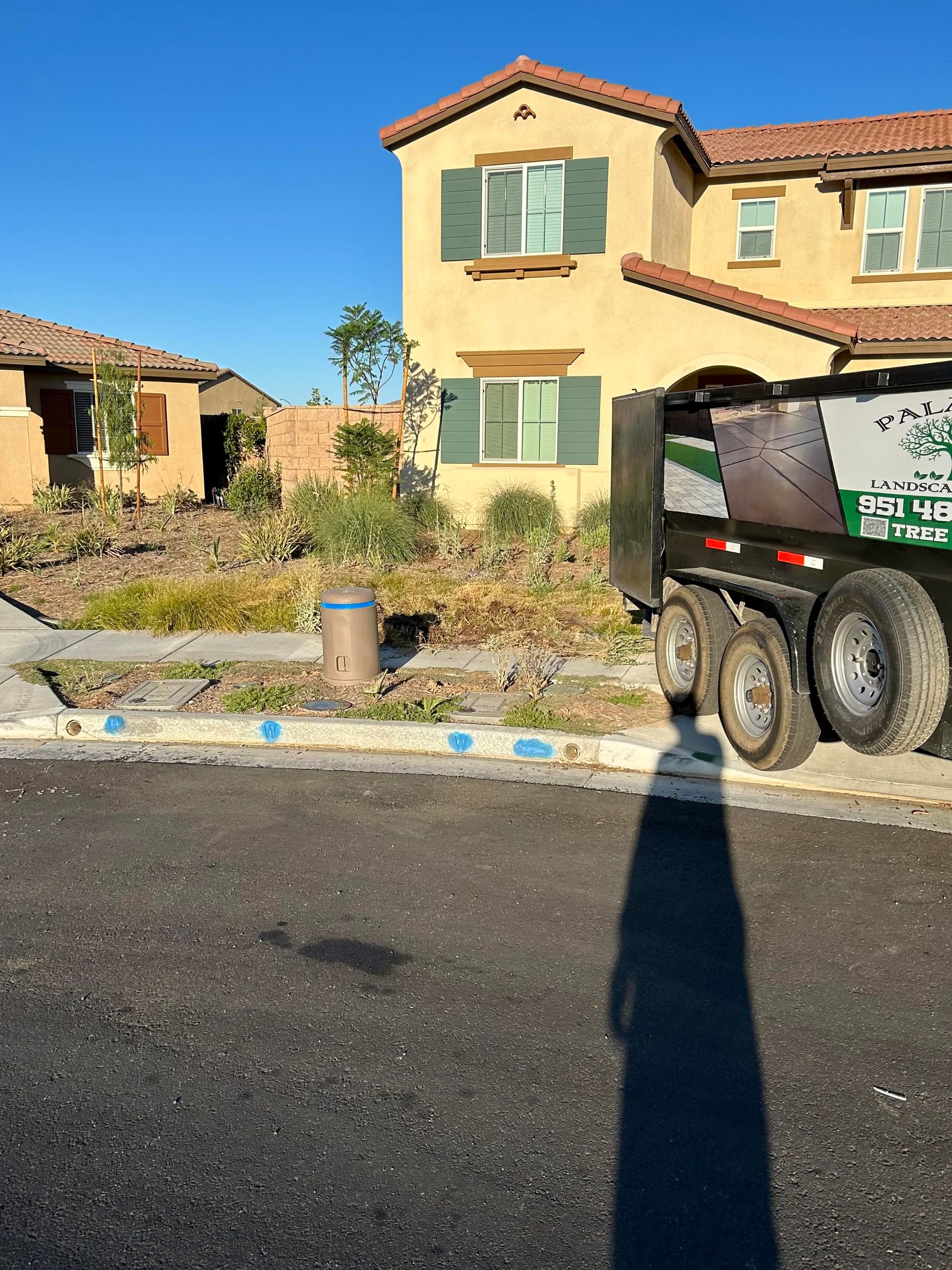 A dump truck is parked in front of a large house.