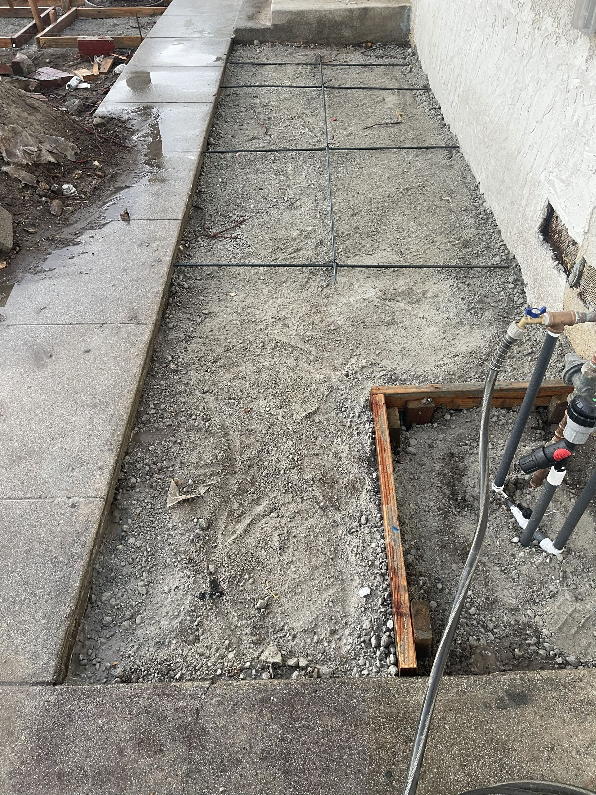 Construction site with gravel, rebar, and wood frame, ready for concrete.