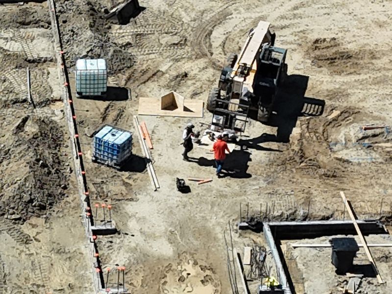 An aerial view of a construction site with workers and machinery
