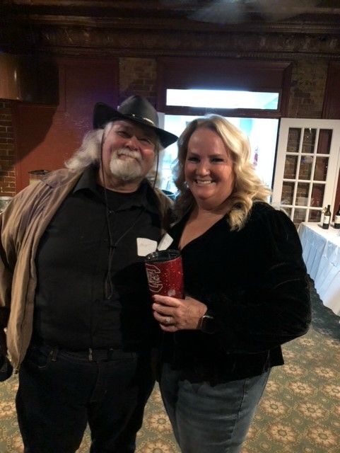 A man and a woman are posing for a picture in a room.