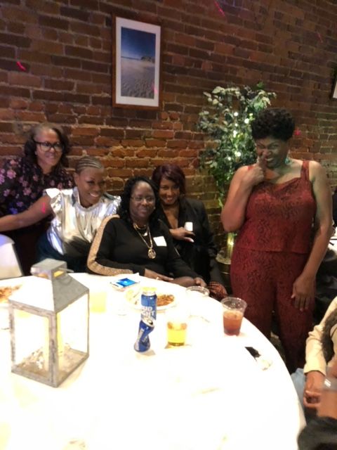 A group of women are sitting around a table with drinks
