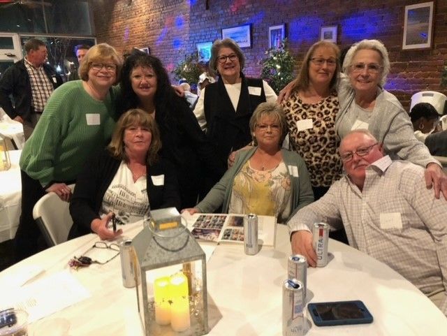 A group of people are posing for a picture at a table.