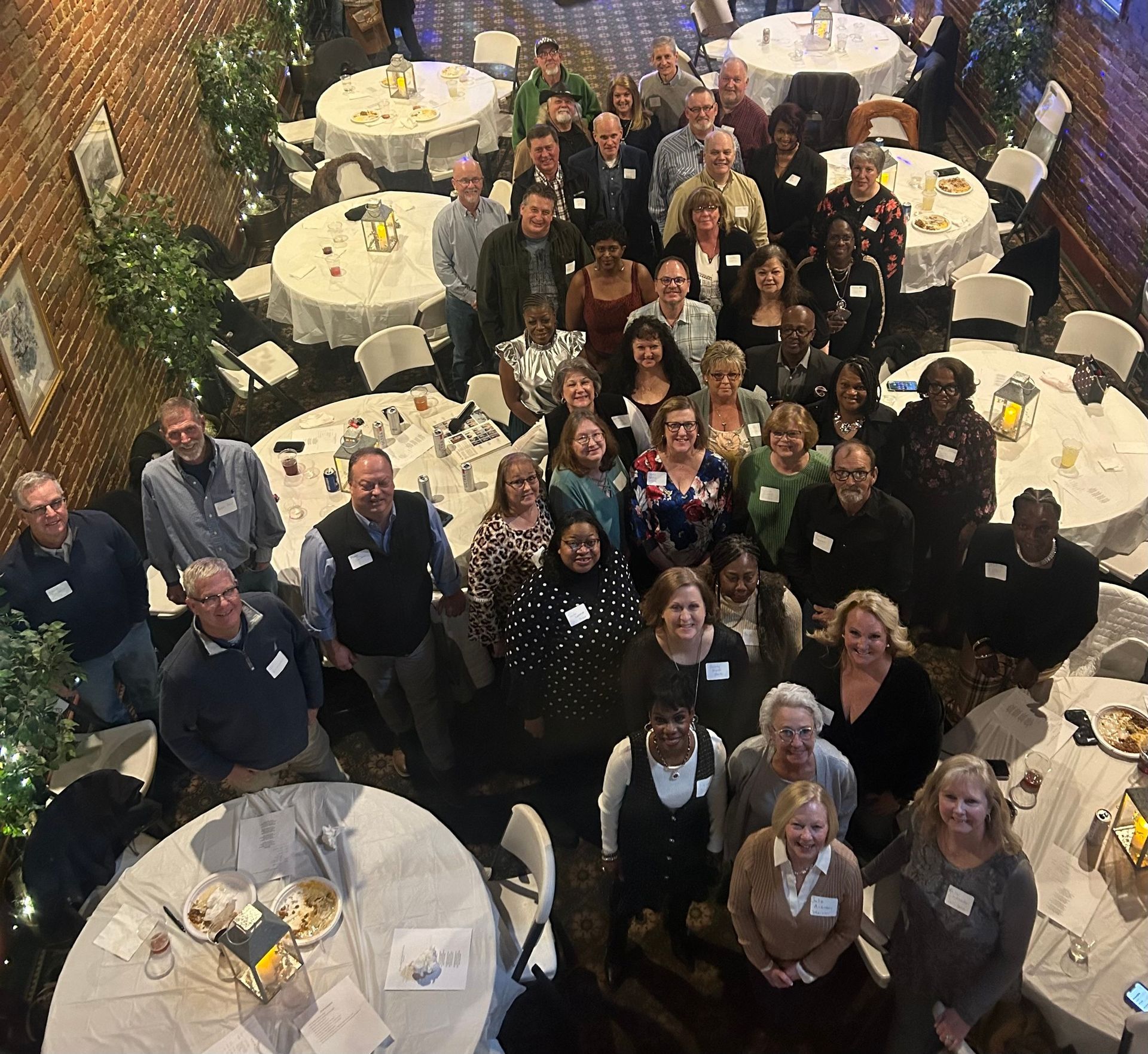 A large group of people are posing for a picture in a restaurant.