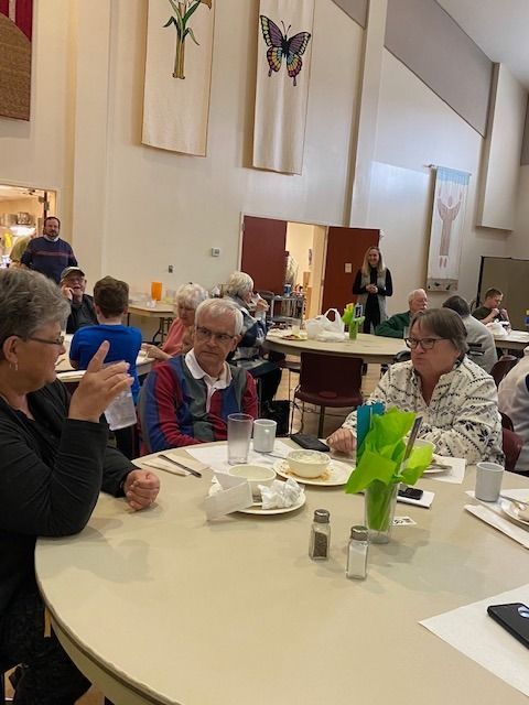 A group of people are sitting at tables in a room.